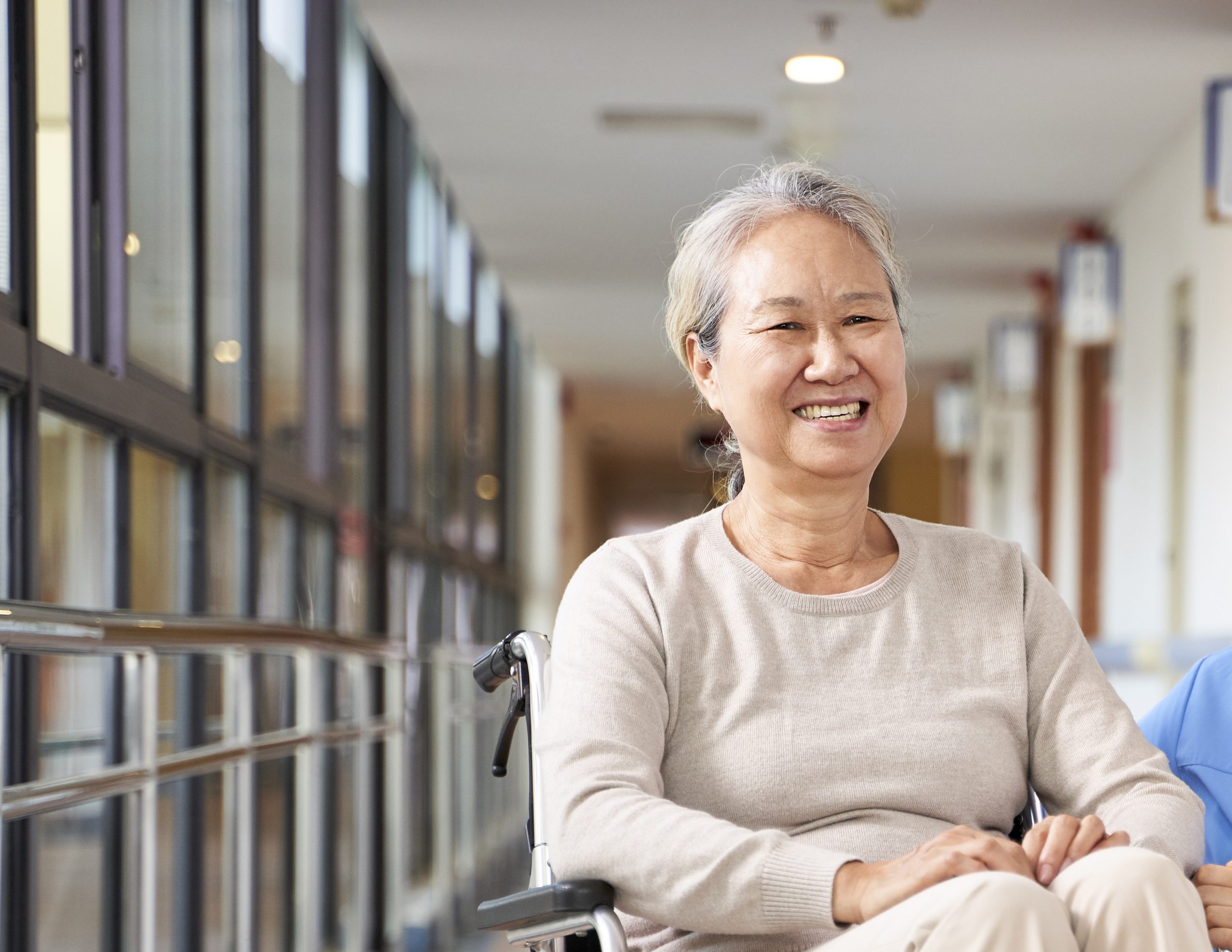 asian senior woman and her caregiver looking at camera smiling